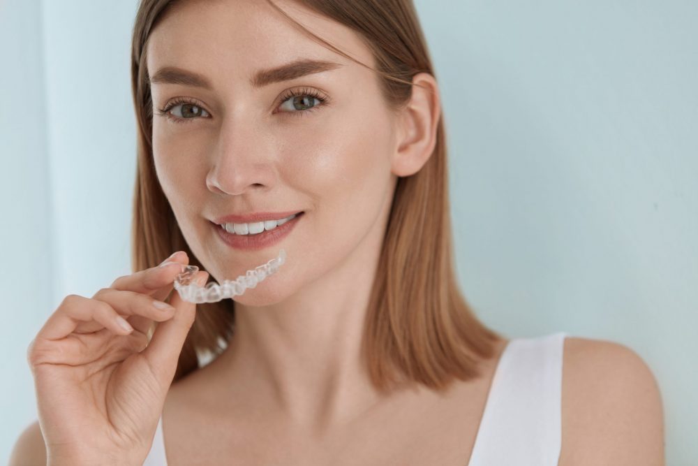 woman with invisalign aligner in hand